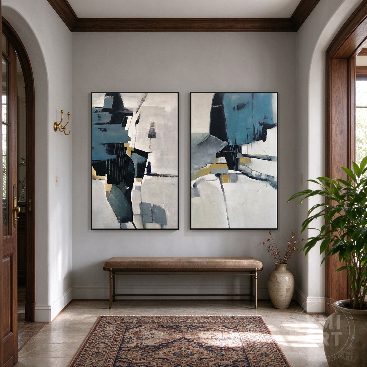 Modern abstract diptych wall art in navy blue, gray, white, and gold displayed in an elegant entryway.